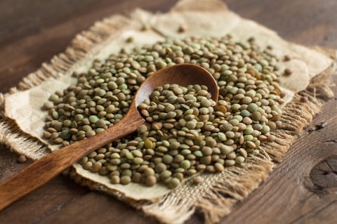 Green lentils on wooden table